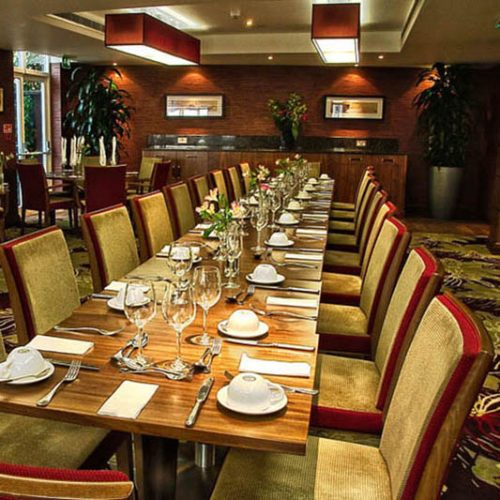 Reupholstered red and gold chairs around a long brown table