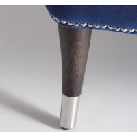 Close-up of wooden chair leg with chrome cap
